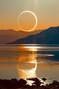 Total solar eclipse event over a lake with reflection.