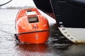 Totally Enclosed Lifeboat floating near big vessel