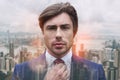 Totally handsome. Close-up portrait of handsome young businessman adjusting his necktie while standing against of Royalty Free Stock Photo