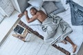 Totally relaxed. Top view of young African man sleeping while lying in the bed at home Royalty Free Stock Photo