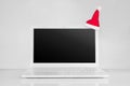 Totally White Laptop With Black Screen And Christmas Red Santa Hat. Pure New Year Concept 2019