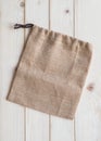 Tote bag with drawstring mockup of small eco sack made from jute hessian canvas or natural hemp burlap flat lay on wood Royalty Free Stock Photo