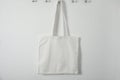 Tote bag hanging on white wall. Mock up