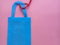 tote bag with red strap on pink background with copy space