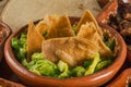 Totopos with guacamole, traditional Mexican food on a clay plate