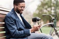 Always in touch. African businessman using smartphone outdoors Royalty Free Stock Photo