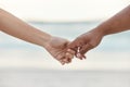 Touch, love and support with interracial couple holding hands in a committed, loving and close relationship. Closeup