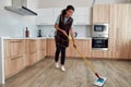 A touch of perfection. Portrait of young happy afro american woman in uniform cleaning floor with mop in the modern Royalty Free Stock Photo