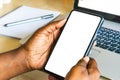 Touch screen mobile phone, in African woman`s hand. Black Female holding smart phone on green outdoor background with blank copy s Royalty Free Stock Photo