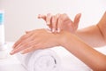 Touch skin, cream and hands in spa, closeup and massage on towel for care. Fingers, nails or person apply lotion in Royalty Free Stock Photo
