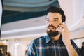 Always in touch. Smiling handsome young man talking on his phone