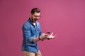 Always in touch. Smiling young man holding smart phone and looking at it. Portrait of a happy man using mobile phone