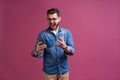 Always in touch. Smiling young man holding smart phone and looking at it. Portrait of a happy man using mobile phone Royalty Free Stock Photo