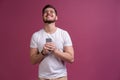 Always in touch. Smiling young man holding smart phone and looking at it. Portrait of a happy man using mobile phone Royalty Free Stock Photo