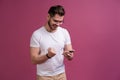 Always in touch. Smiling young man holding smart phone and looking at it. Portrait of a happy man using mobile phone Royalty Free Stock Photo