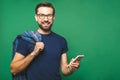 Always in touch. Smiling young man holding smart phone and looking at it. Portrait of a happy man using mobile phone isolated over Royalty Free Stock Photo