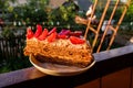 Touched by evening sunlight delicious piece of homemade cake with strawberry and whipped cream on a white pearl plate, with Royalty Free Stock Photo