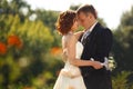 Touches - bride strokes groom's head standing in the park