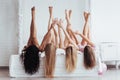 Touching with hands. Four young women with good body shape lying on the bed with their legs up