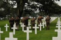 Touching view of men in uniform saluting in the Normandy American Cemetery