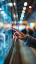 Touchscreen interaction with hand in public space, modern technology use with blurred background lights Royalty Free Stock Photo