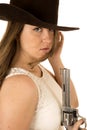 Tough cowgirl holding pistol staring down expression on camera