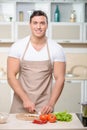 Tough guy chops vegetables in kitchen