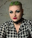 Tough looking punk girl. Facial piercings & green hair, spiked collar.