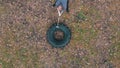 Tough tattooed bodybuilder hitting the truck tire with a heavy iron hammer - training in the autumn forest