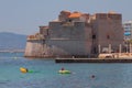 Toulon, France - Jul 01,2019: Bathing people and an ancient fort on sea coast