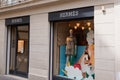 Hermes logo brand and text sign front of store windows of French high fashion shop