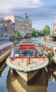 Tour boat with ancient mansion and drawbridge on background, Amsterdam, Netherlands