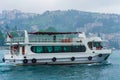 Tour boat on Bosphorus strait on rainy spring day Istanbul city Turkey