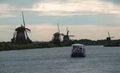 Tour boat on a canal with the famous Dutch windmills at Kinderdijk: an UNESCO world heritage site. Royalty Free Stock Photo