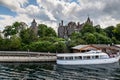 Tour boat at the dock of Heart island with Boldt castle in the background, on St Lawrence river Royalty Free Stock Photo