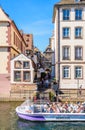 A tour boat full of tourists stationing at a pier in the historic district in Strasbourg, France Royalty Free Stock Photo