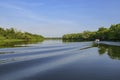 Tour boat on a glassy Pantanal river in afternoon light with water reflections, Pantanal Wetlands, Mato Grosso, Brazil