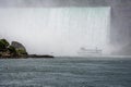 Tour boat in the mist under Horseshoe Falls on the Niagara River Royalty Free Stock Photo