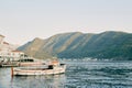 Tour boat is moored near the promenade with covered open-air restaurants. Perast, Montenegro