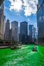 Tour boats cross a dyed green, vibrant Chicago River during St. Patrick`s Day