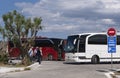 Tour buses and tourists departing their visit to Elounda, Crete.