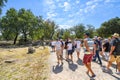 A tour group passes through the ancient streets and alongside the Greek ruins at Olympia, Greece