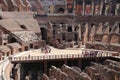 Tour groups in the arena of the Colosseum, among the ancient ruins of the Flavian amphitheater
