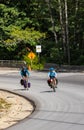 Touring bicycles riding in Vancouver Island, Canada. Woman and man cycling on a mountain road taking a curve