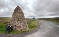 Touring bike leans against a large stone cairn, or currick, at Shorngate Cross on the border of Northumberland and County Durham, Royalty Free Stock Photo