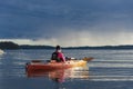 Touring kayaking woman and rainclouds Stockholm archipelago