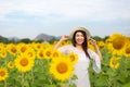 Tourism Asia woman standing relax chill in the sunflower field in vacations time. People freedom and enjoy in the spring meadow