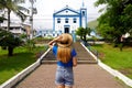 Tourism in Brazil. Back view of tourist girl in front of the church Igreja Matriz in the historic center of Ilhabela Island,