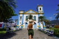 Tourism in Brazil. Back view of young tourist woman in front of the church Igreja Matriz in the historic center of Ubatuba, Brazil