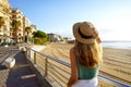 Tourism in Calabria. Back view of girl holding straw hat walking on Crotone promenade on Calabria coast, Italy Royalty Free Stock Photo